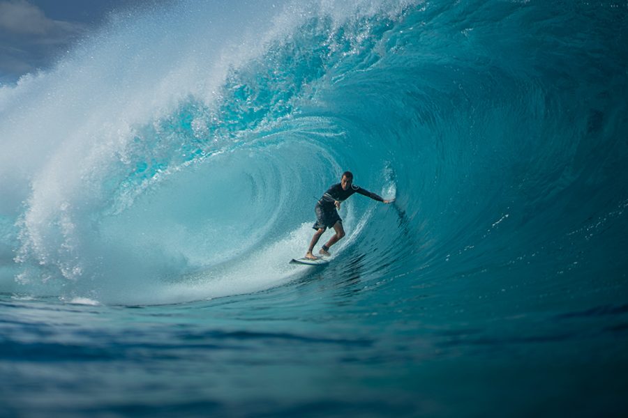 Luca wurde während des Surfens Fotografiert, während eine Welle über ihm zusammenfällt.